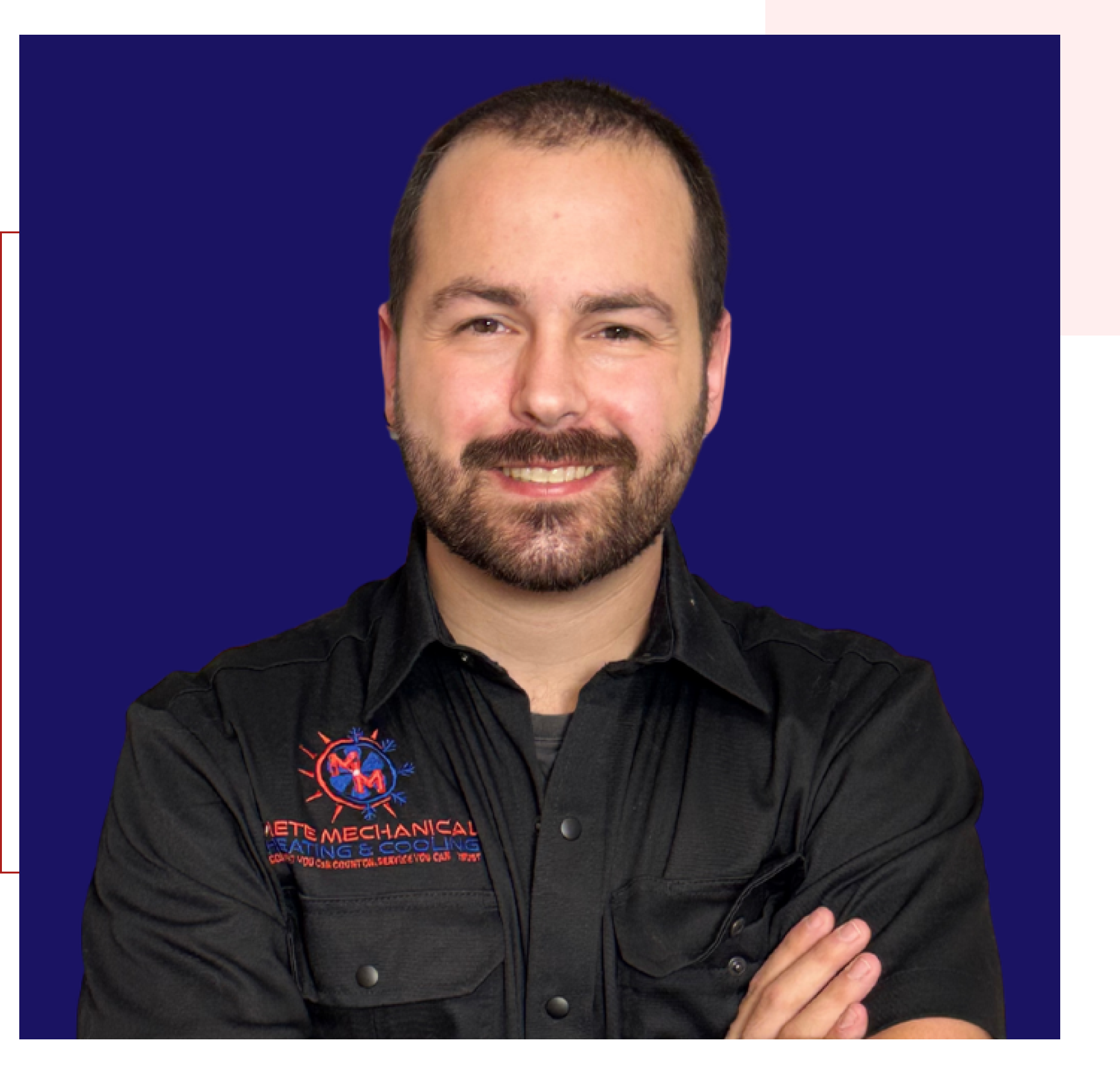 Smiling man in black shirt, arms crossed.