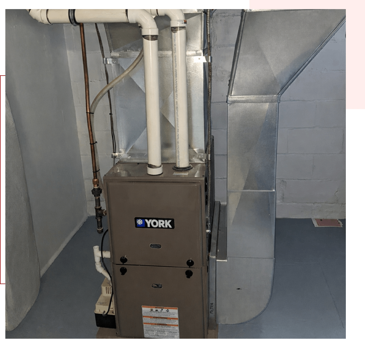 A gray Lennox furnace unit installed in a basement with ductwork.